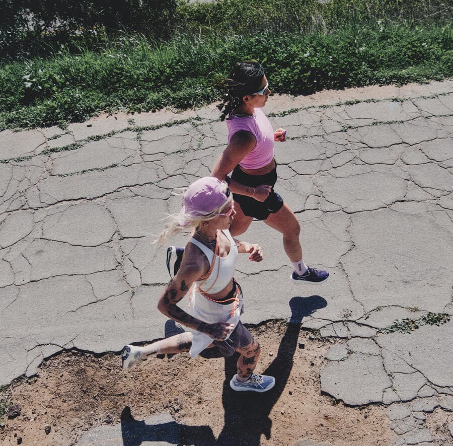 Two girls running on a road